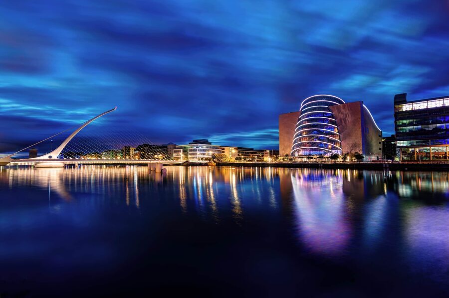 Night view of the Dublin Convention Centre and Samuel Beckett Bridge reflecting on the River Liffey.